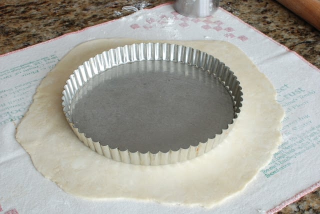 rolled out pie dough with tart tin