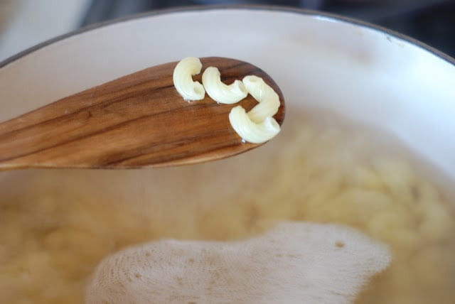 Cooked macaroni on a wooden spoon