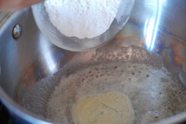 flour being added to melted butter in a pan
