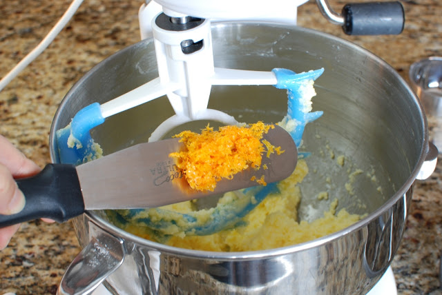Orange zest being added to batter in mixer