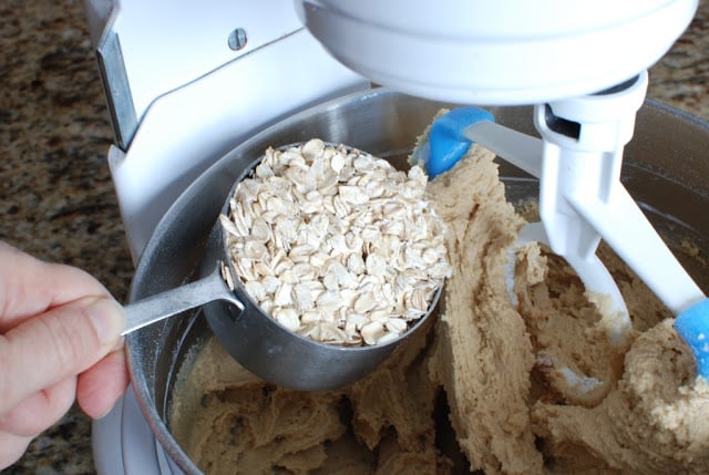 Scoop of oatmeal added to mixing bowl