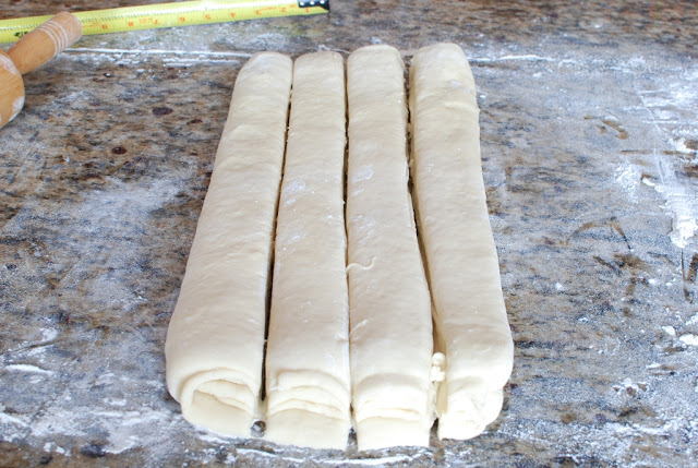 Butterflake dough cut into 4 long strips all side by side.
