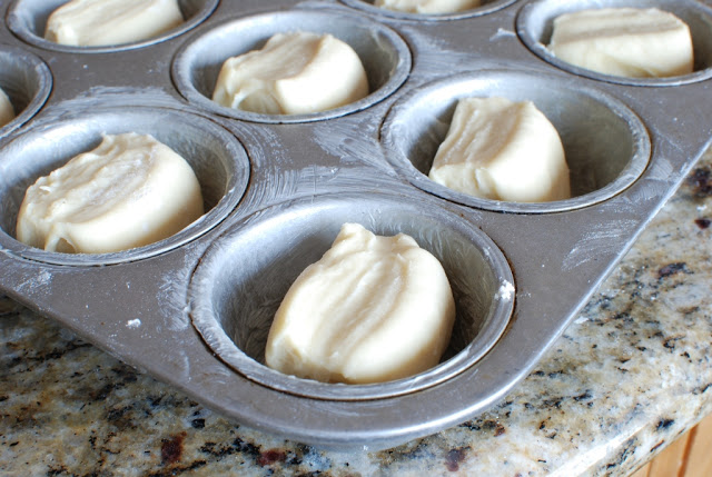 Muffin tin with dough pieces.