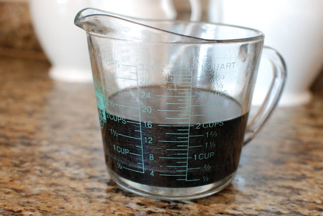 Reduced cherry cola in measuring cup.