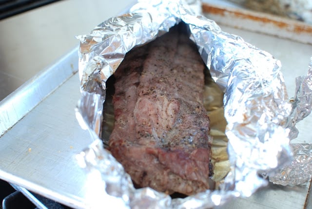 Baked ribs in surrounded by foil.