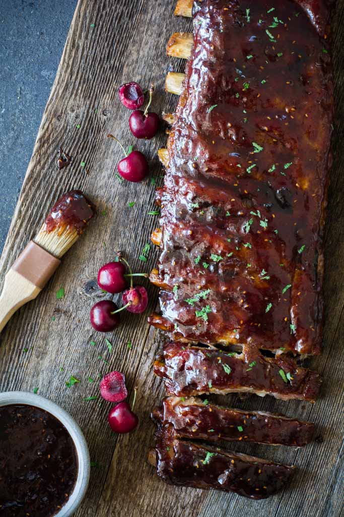 glazed ribs with cherries on wood board