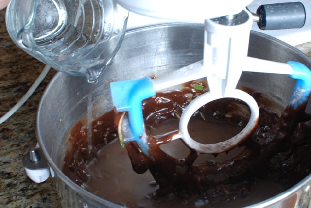 hot water pouring into chocolate zucchini cake batter