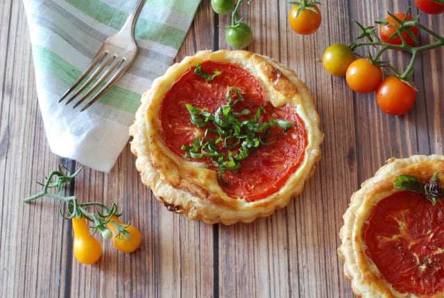 small round tomato tart with basil garnish