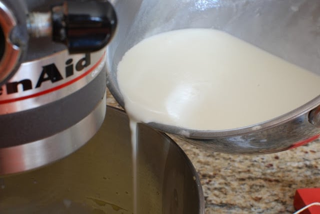 hot milk mixture pouring into beaten eggs and sugar