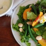 peaches, green beans, almonds, greens, and ricotta on white plate