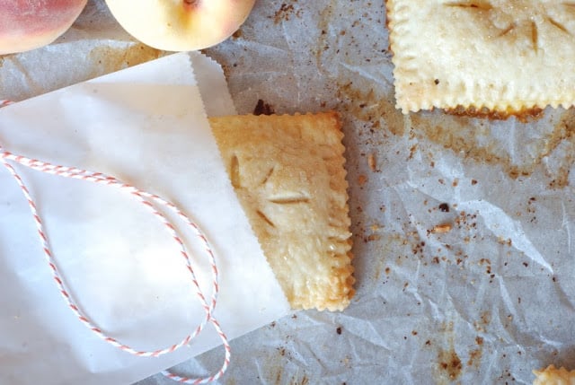 hand peach pie in a glassine bag on baking sheet with red and white twine