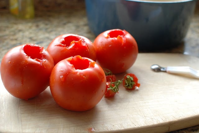 Cores tomatoes on cutting board