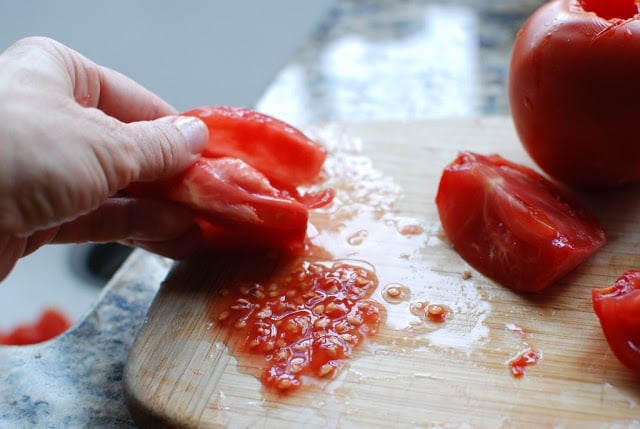 quartered tomato being seeded