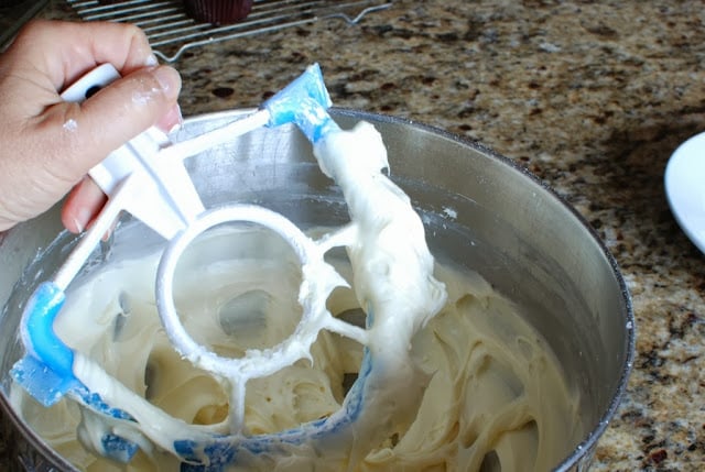 Large bowl of cream cheese icing with paddle attachment being removed