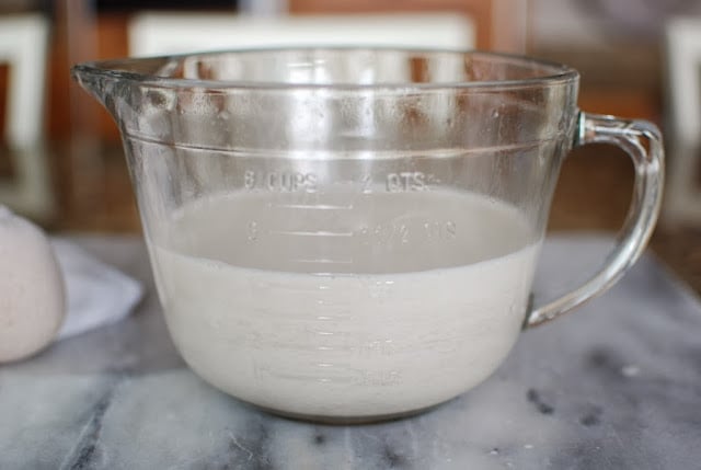 glass measuring cup filled with almond milk