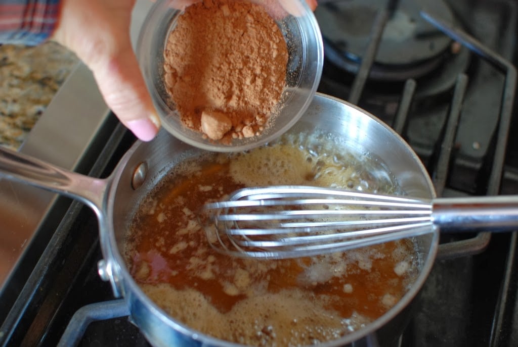 Melted oil, honey, in pan adding cocoa powder