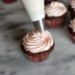 Piping swirl of buttercream on top of a chocolate cupcake