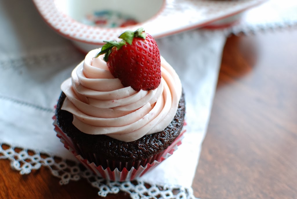 chocolate cupcake with strawberry icing with whole strawberry on top
