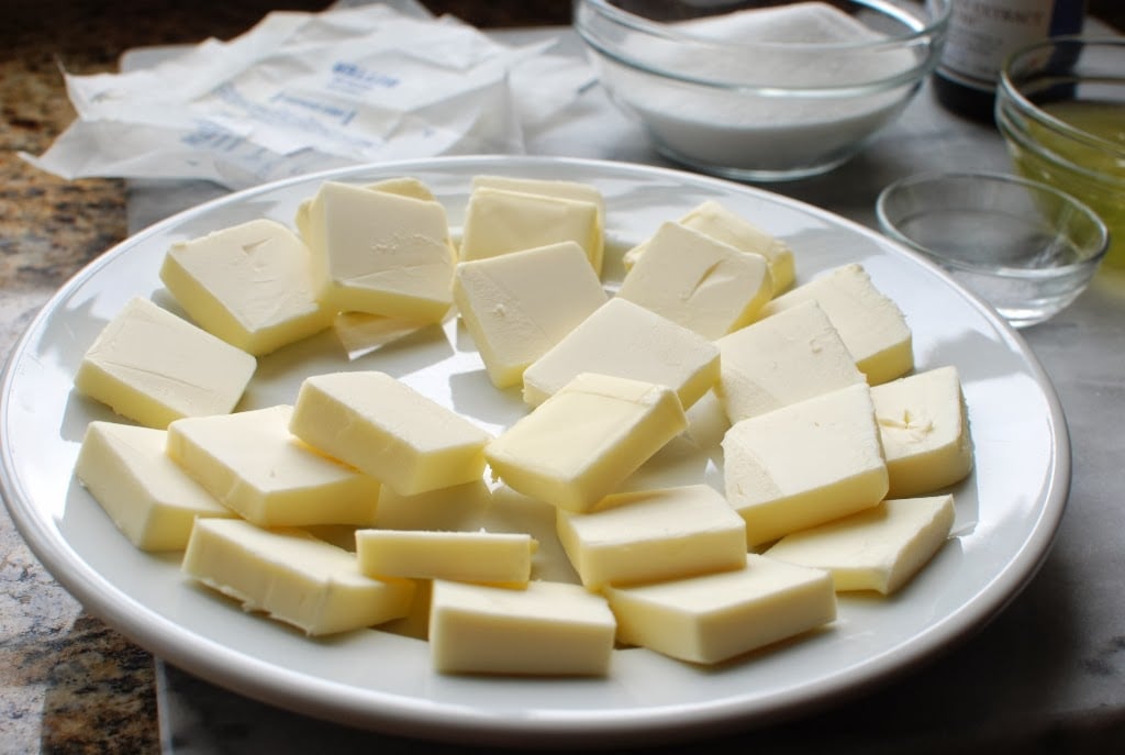 butter cut into squares stacked on a white plate