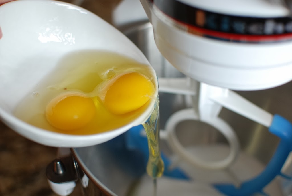 Two eggs added to sugar in in mixing bowl