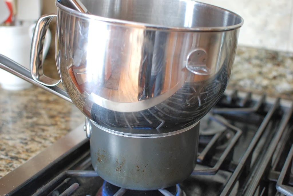 stainless steel mixing bowl sitting on top of saucepan of water
