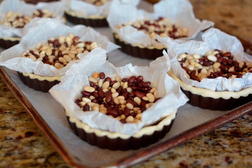 small quiche on with parchment and pie weights