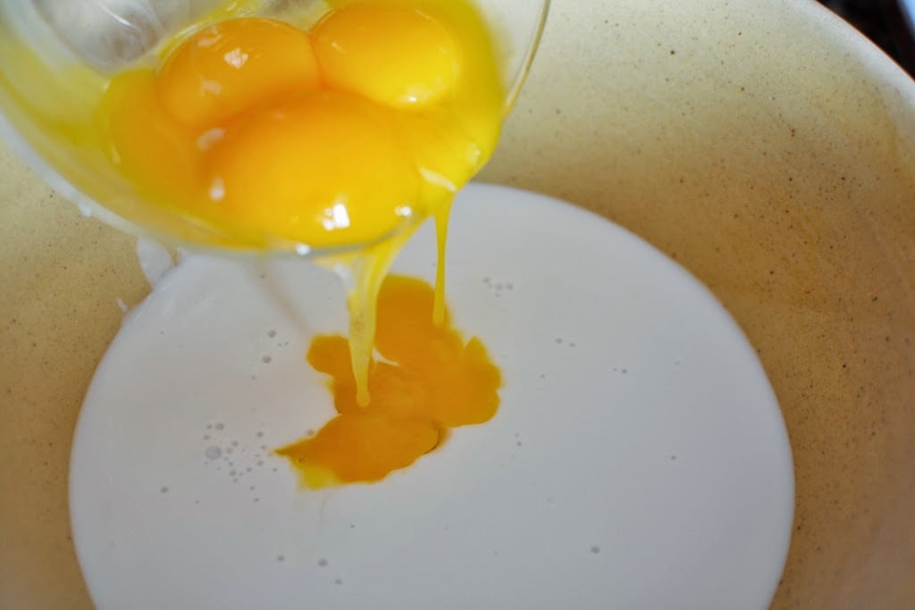 Coconut milk and egg yolks in bowl