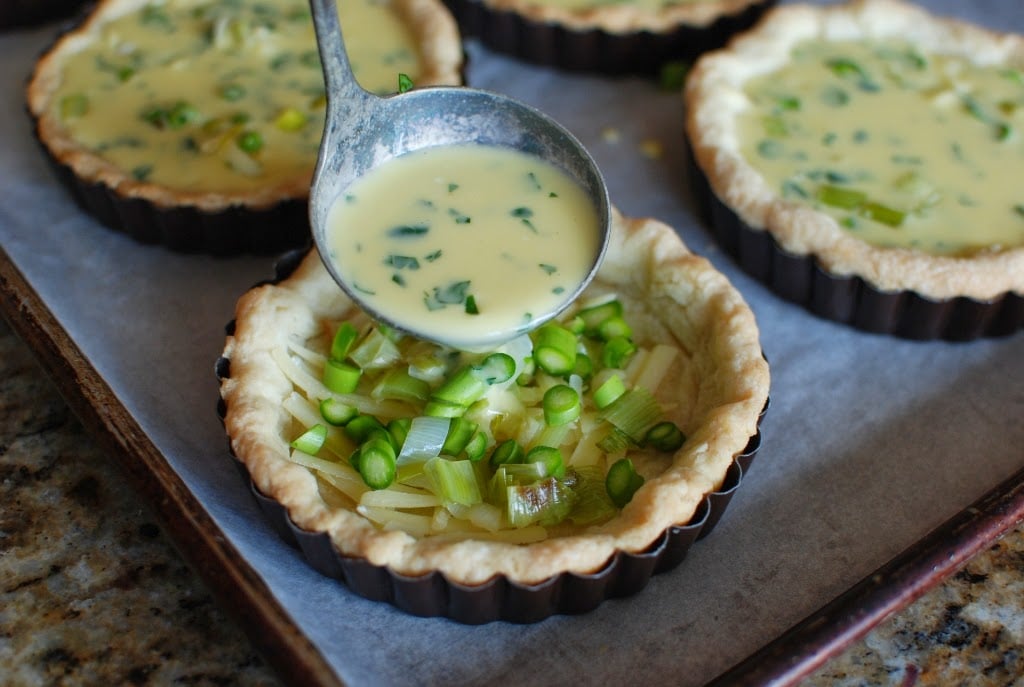 spooning custard into quiche shells