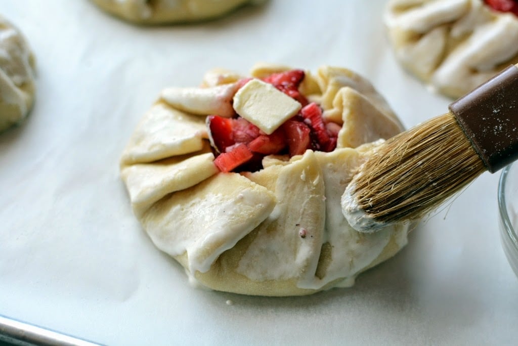 brushing cream on pie dough