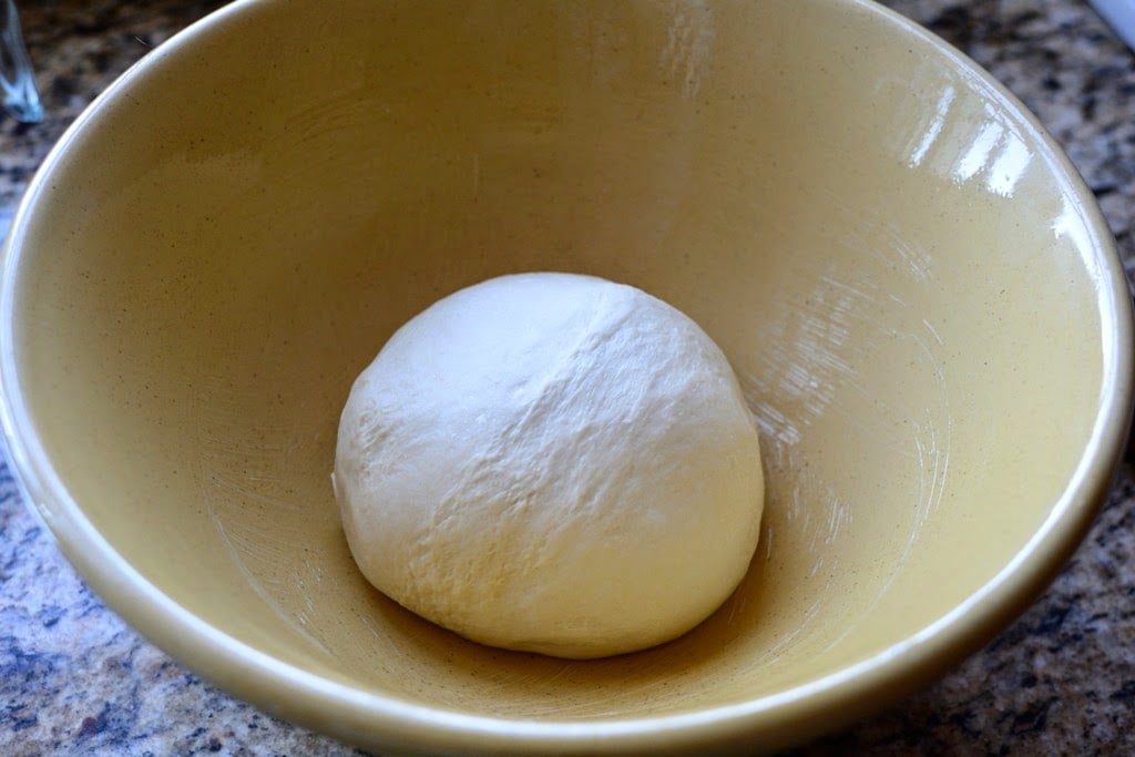 prepared ball of dough in yellow bowl