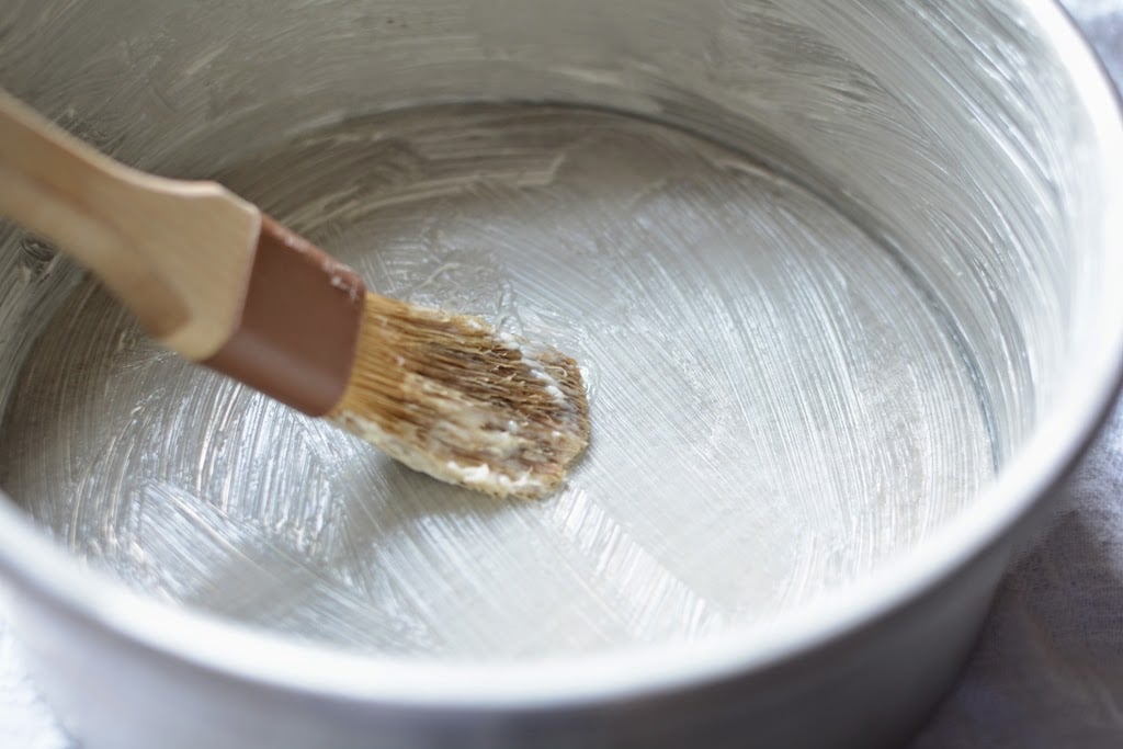 round baking pan buttered with pastry brush