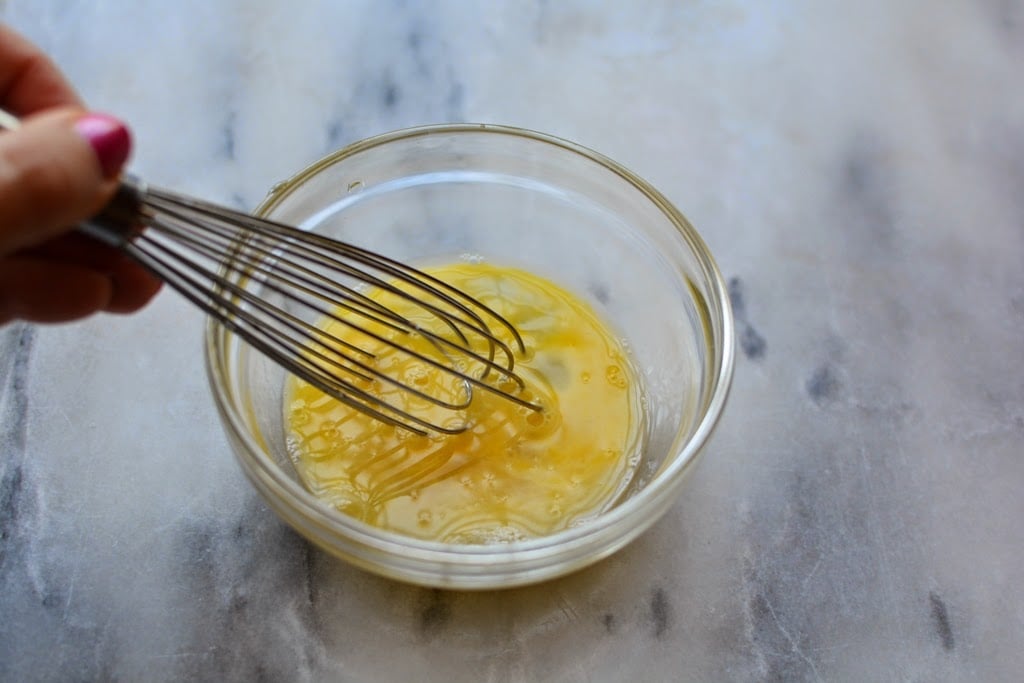 whisking egg in glass bowl