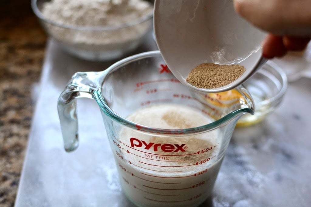 yeast being added to milk in measuring cup