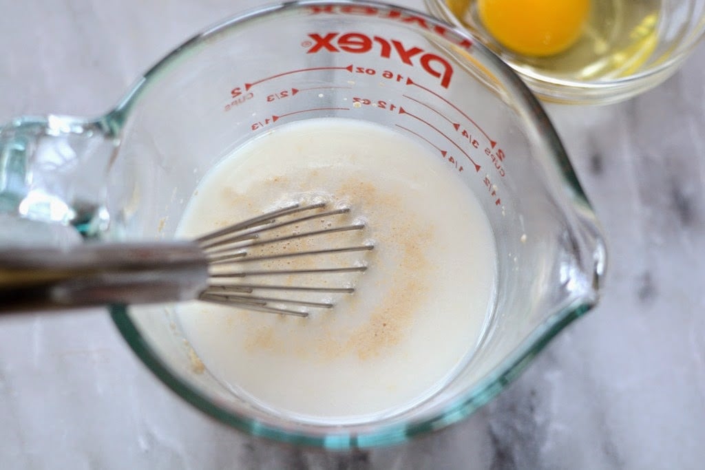 small whisk in measuring cup of milk