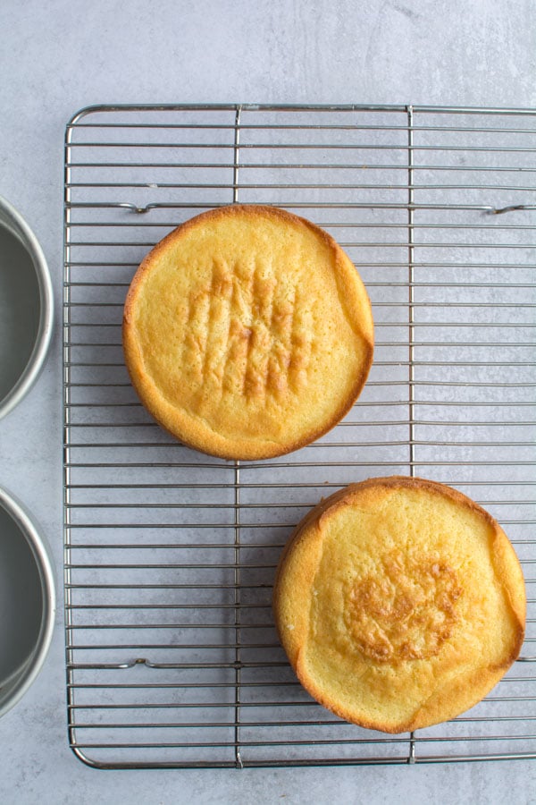 two round cakes on cooling rack