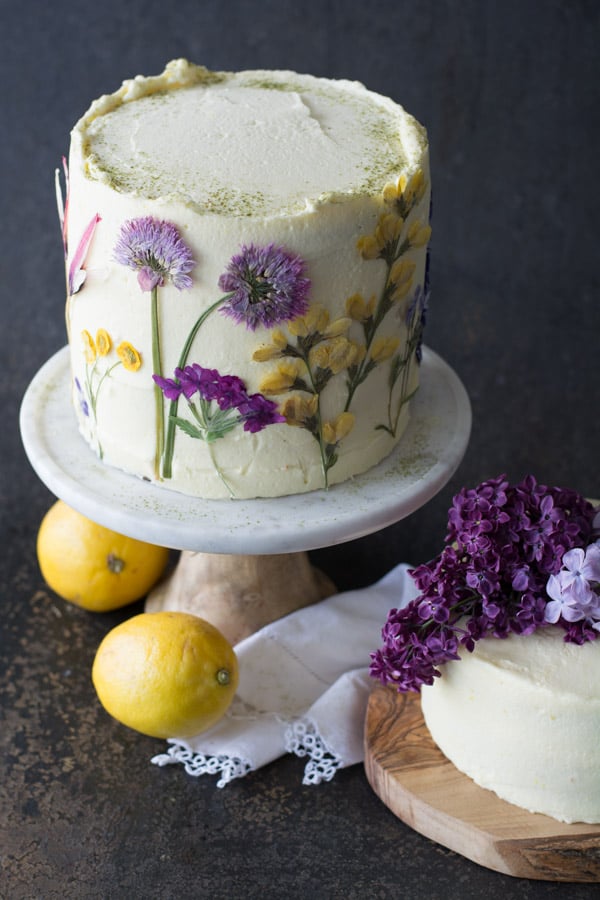 Lemons by a lemon olive oil cake with pressed flowers.