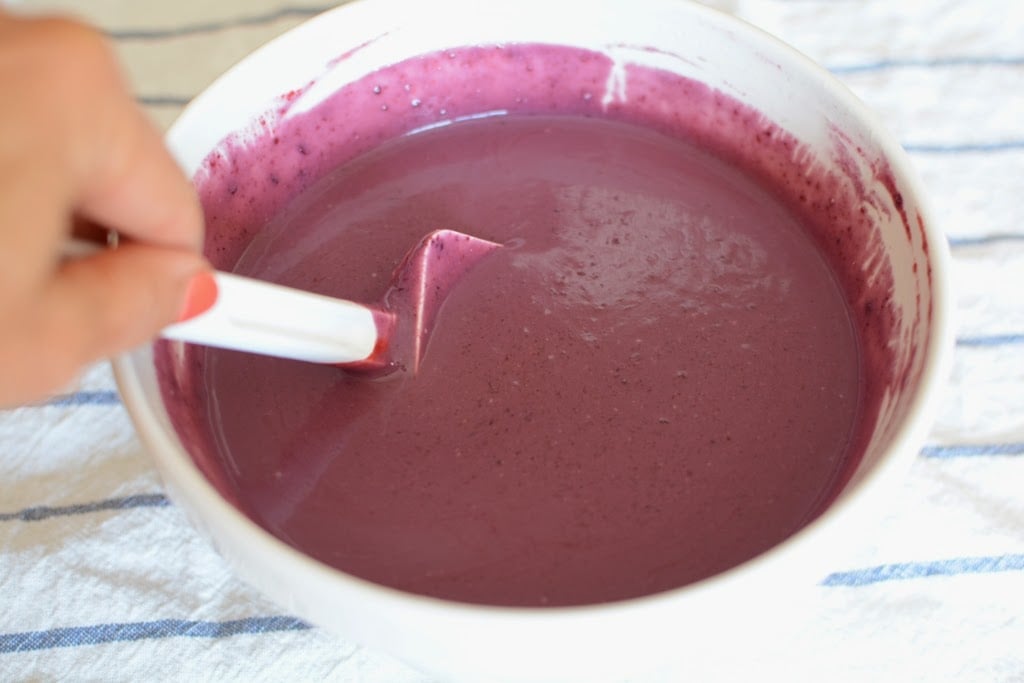 blackberry ice cream base in white bowl with white spatula