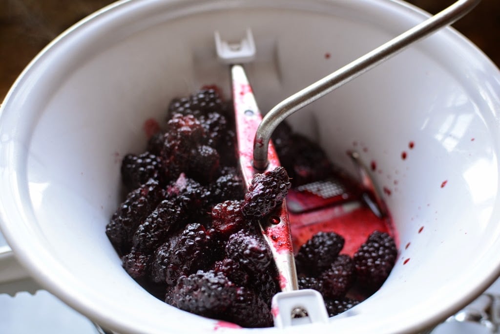 cooked blackberries in a white food mill