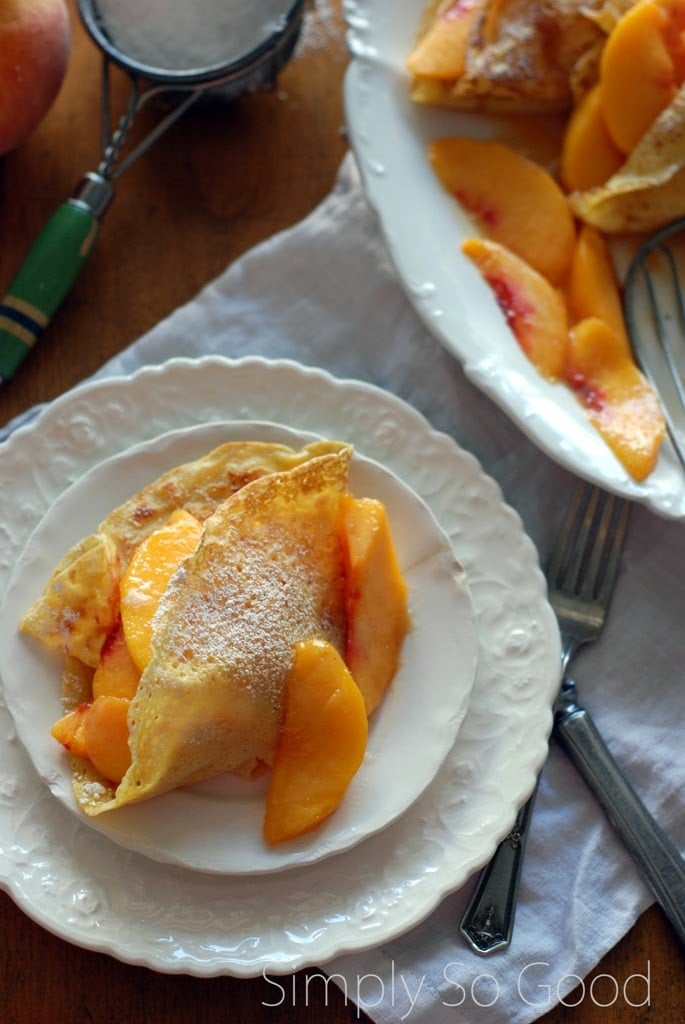 white plate with crepe filled with peaches