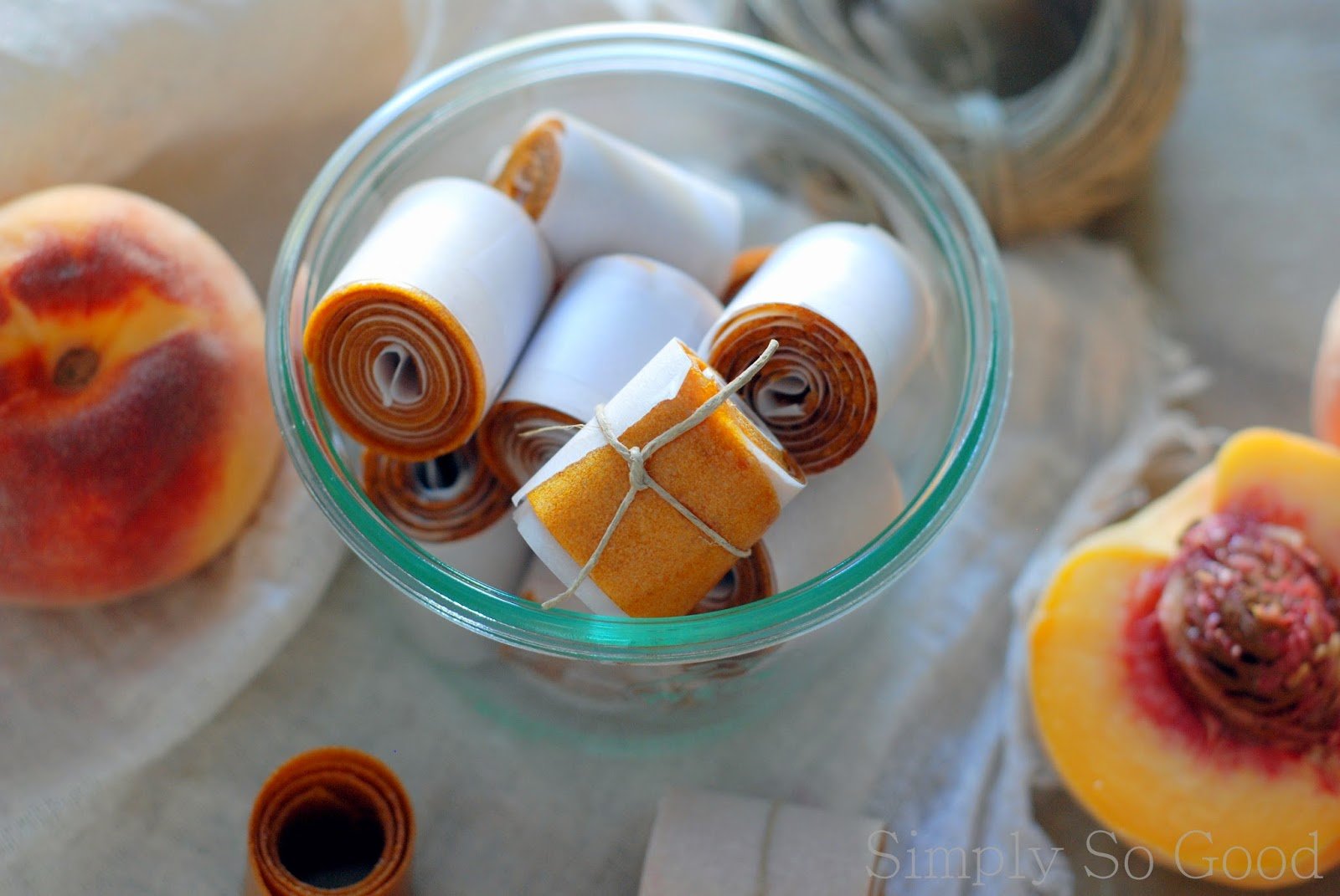 glass bowl with rolls of peach leather tired with string