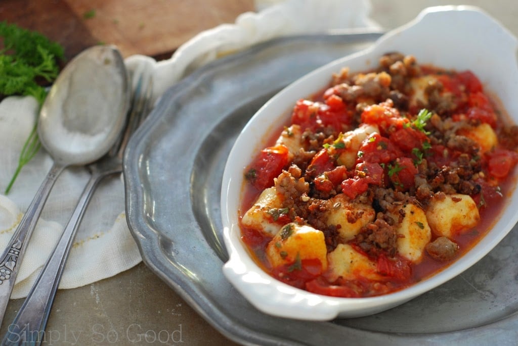 ricotta gnocchi in tomato sauce, sausage, in white bowl