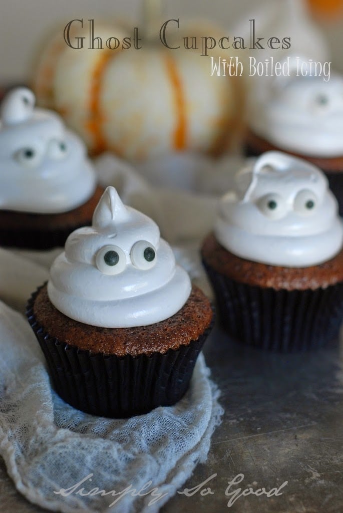 chocolate cupcakes with boiled icing piped into ghosts with candy eyes