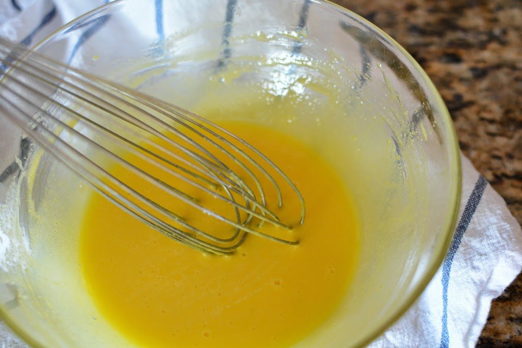 Egg and sugar mixture whisked in a glass bowl.
