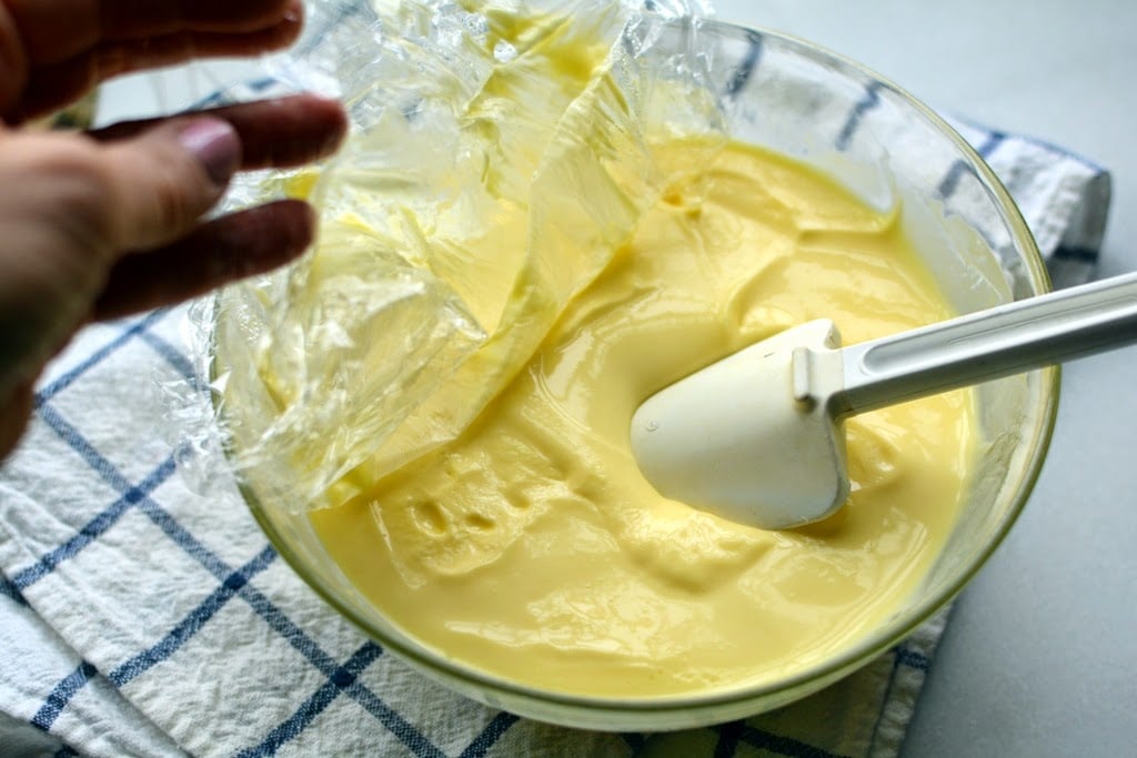 Chilled thick vanilla ice cream custard with white spatula stirring