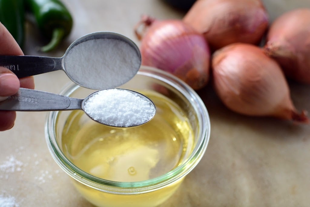 bowl of vinegar with sugar being added