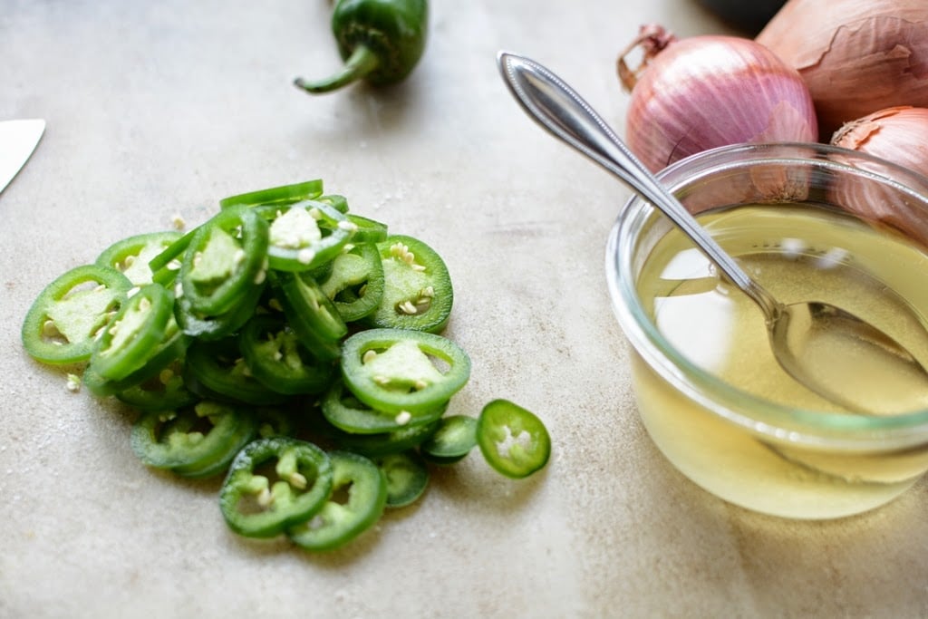 slice jalapenos next to bowl of vinegar