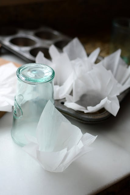 Muffin tin filled with homemade parchment paper cupcake wrappers.