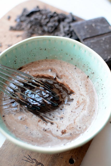 Whisk mixing melted chocolate and hot milk mixture.