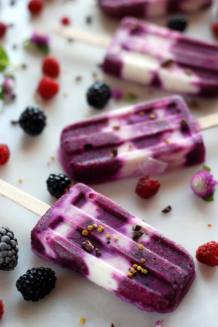 frozen pitaya popsicles with berries sprinkled around