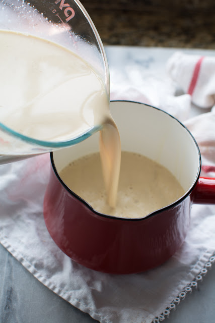 Spiced milk pouring into red pan